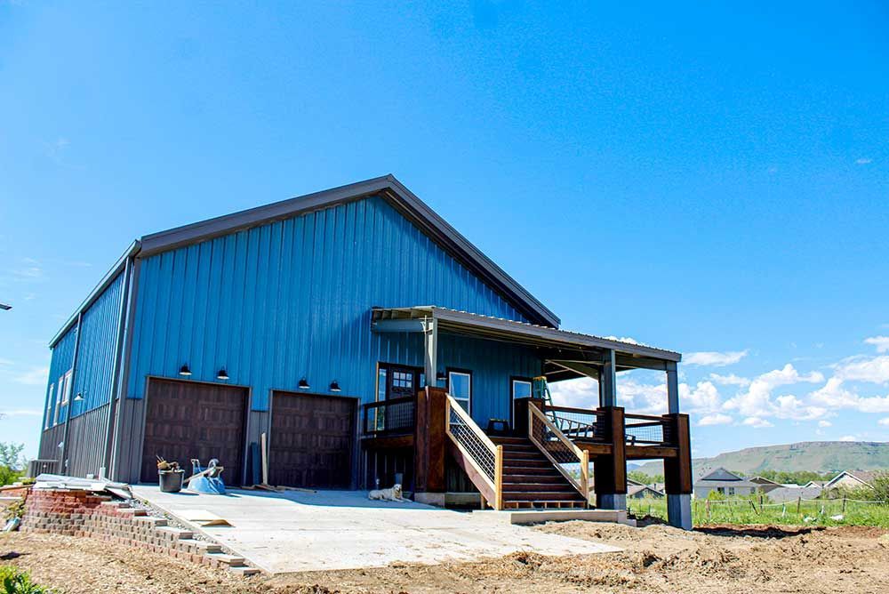 A large blue barn with stairs leading up to it.