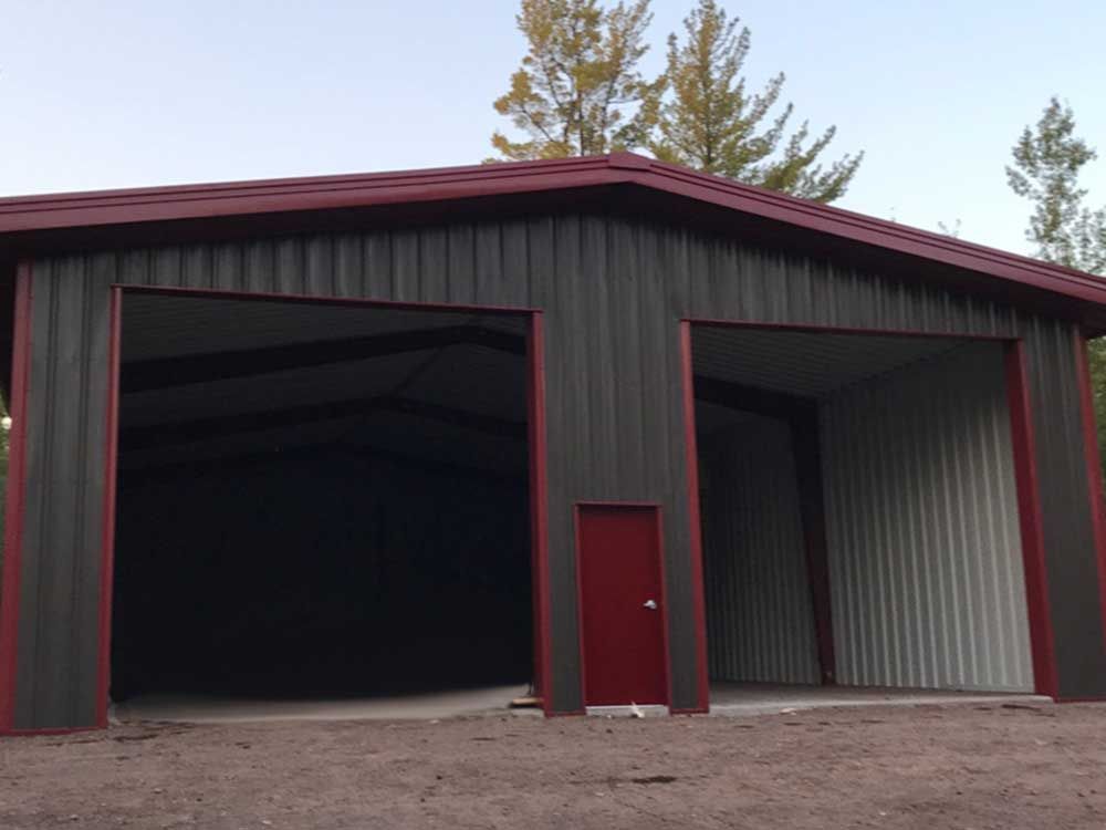 A large metal building with two large doors and a red door.