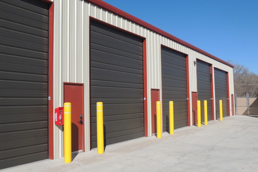 A row of garage doors with yellow poles in front of them