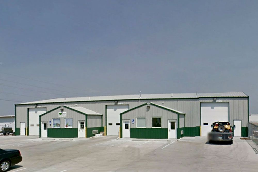 A car is parked in front of a large building