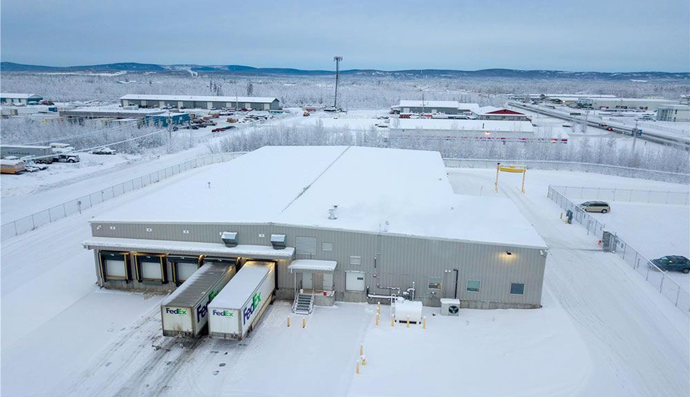 An aerial view of a warehouse covered in snow.