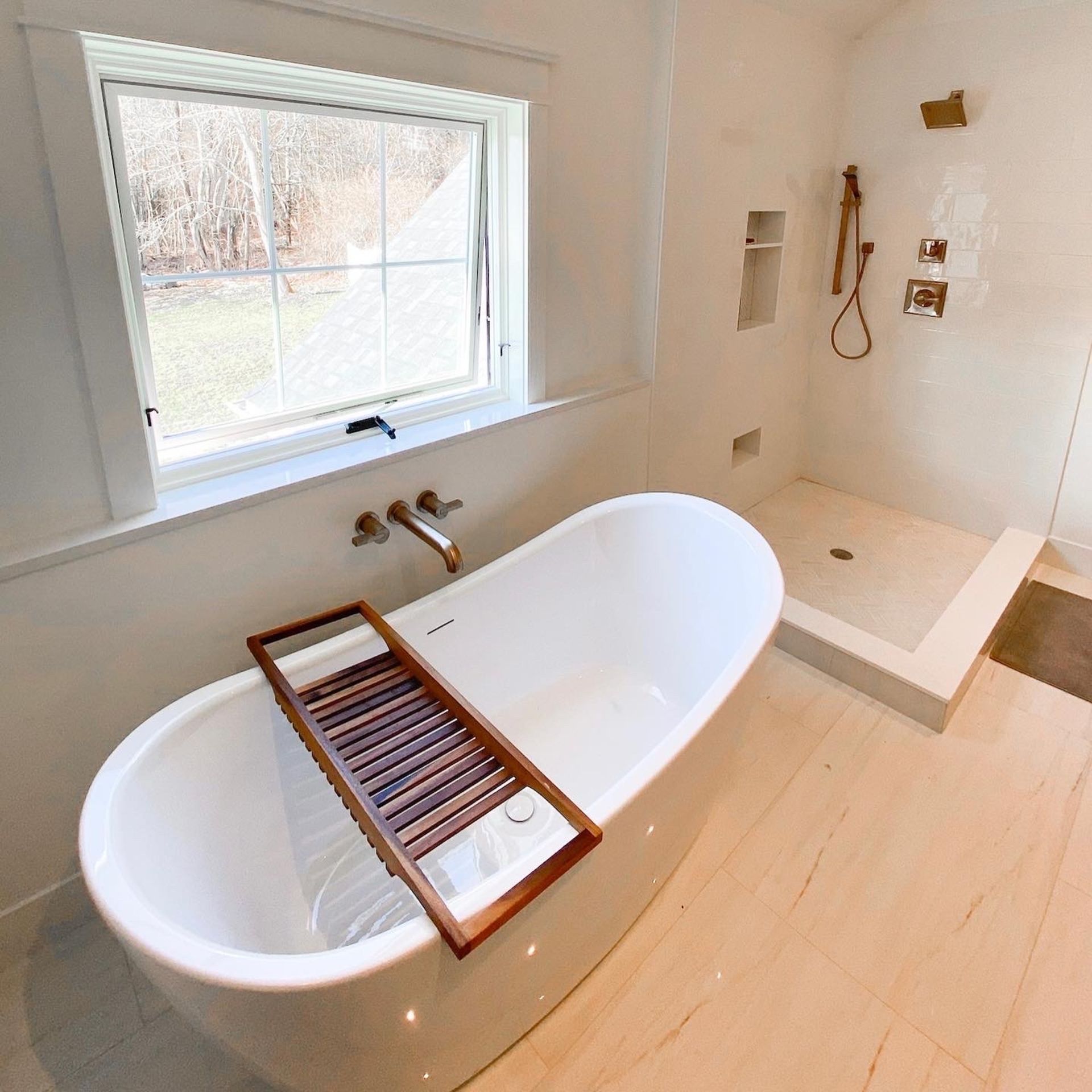 A bathtub with a wooden tray on top of it in a bathroom