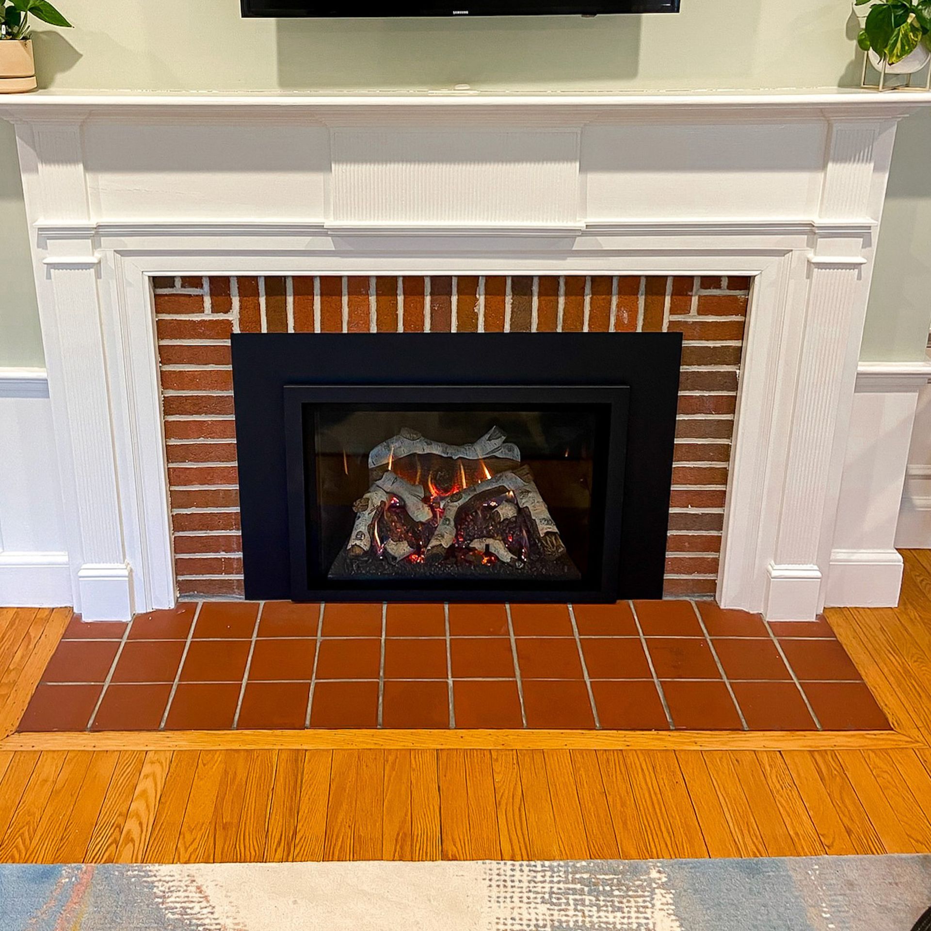 A fireplace in a living room with a flat screen tv above it
