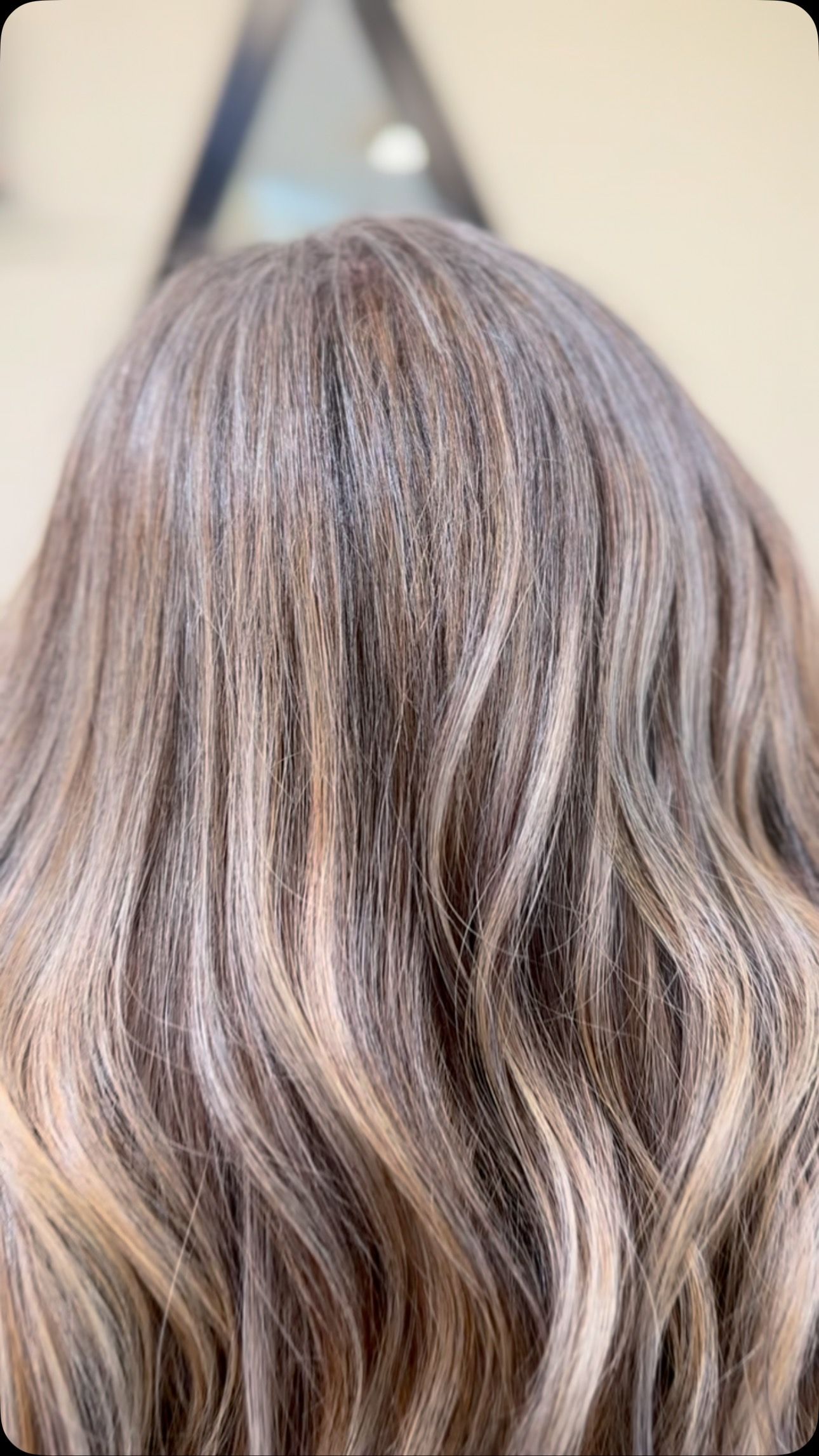 Close-up of hair with highlights, various shades of brown and blonde, textured, wavy.