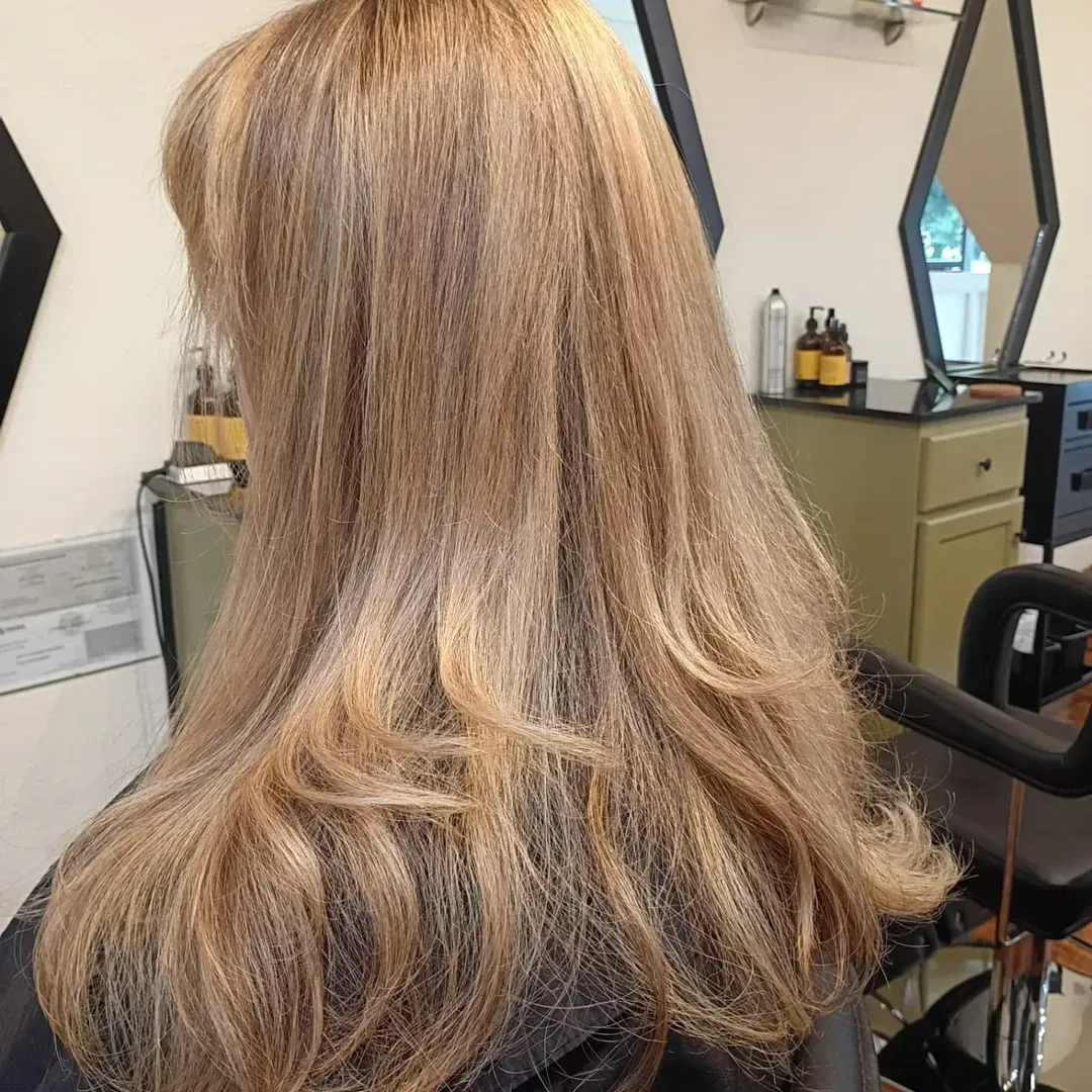Blonde hair, styled in layers, in a salon.