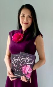 A woman in a purple dress is holding two books.