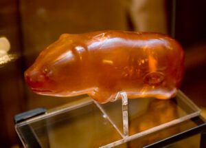 A gummy bear is sitting on top of a glass display case.