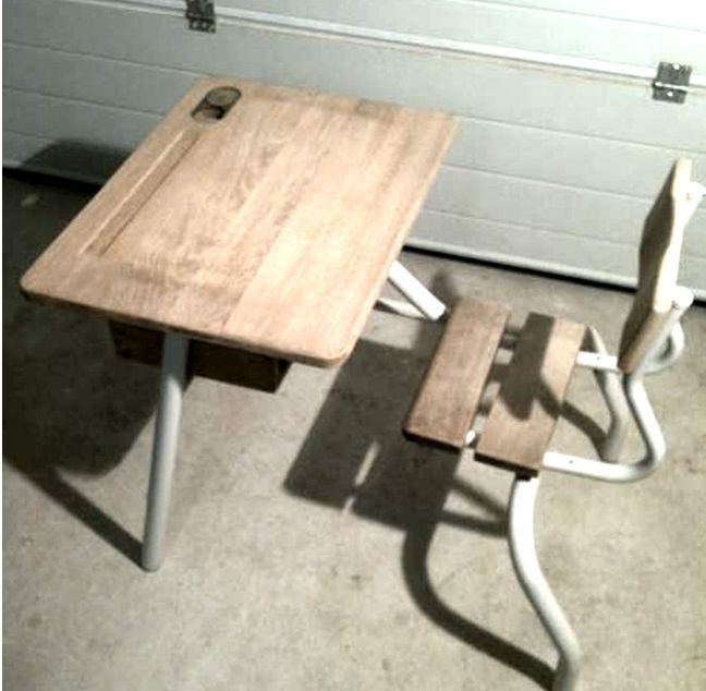 A wooden desk and chair in front of a garage door