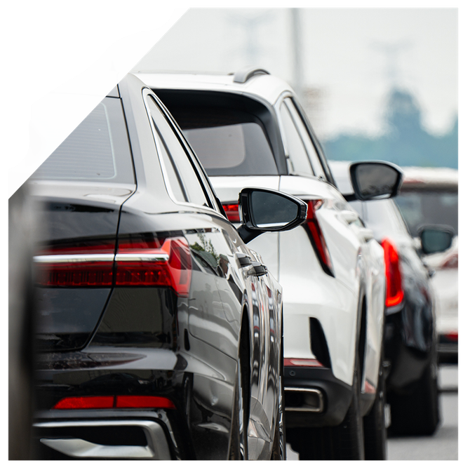 Black sedan and white SUV in traffic, close-up of rear ends, side mirrors visible. Black sedan and white SUV in traffic, close-up of rear ends, side mirrors visible.