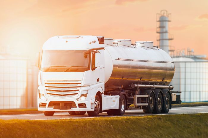 Tanker truck carries fuel for industrial supply chain.