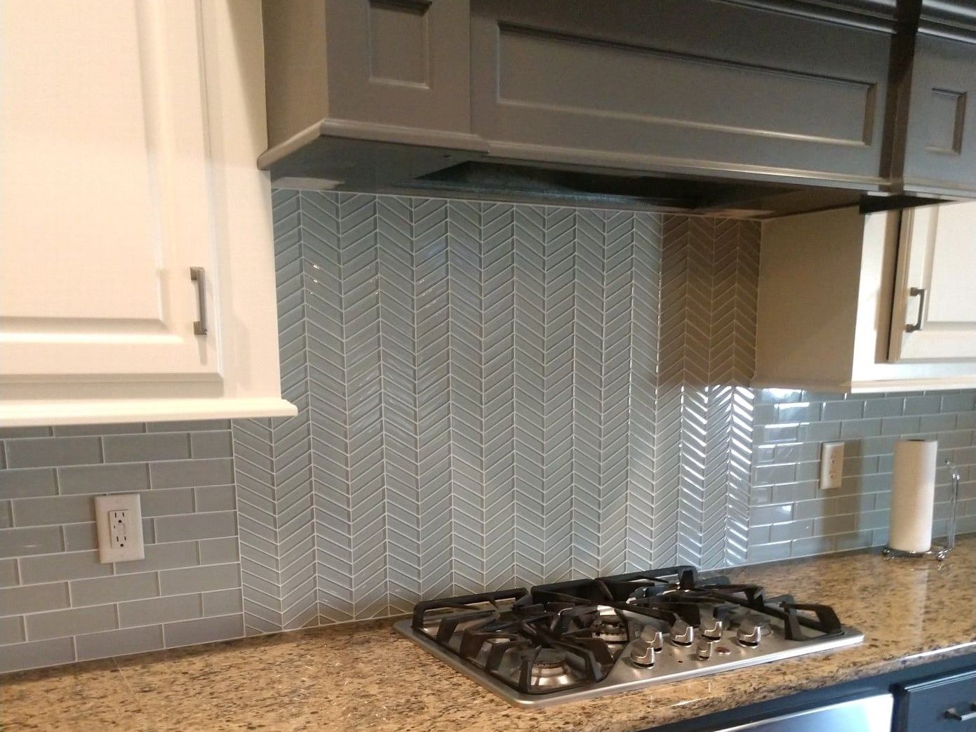 A kitchen with a stove top oven and a hood above it