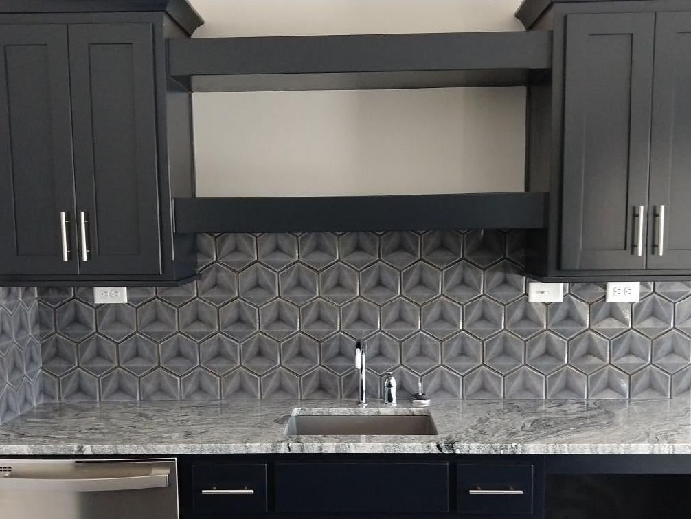 A kitchen with black cabinets and a sink