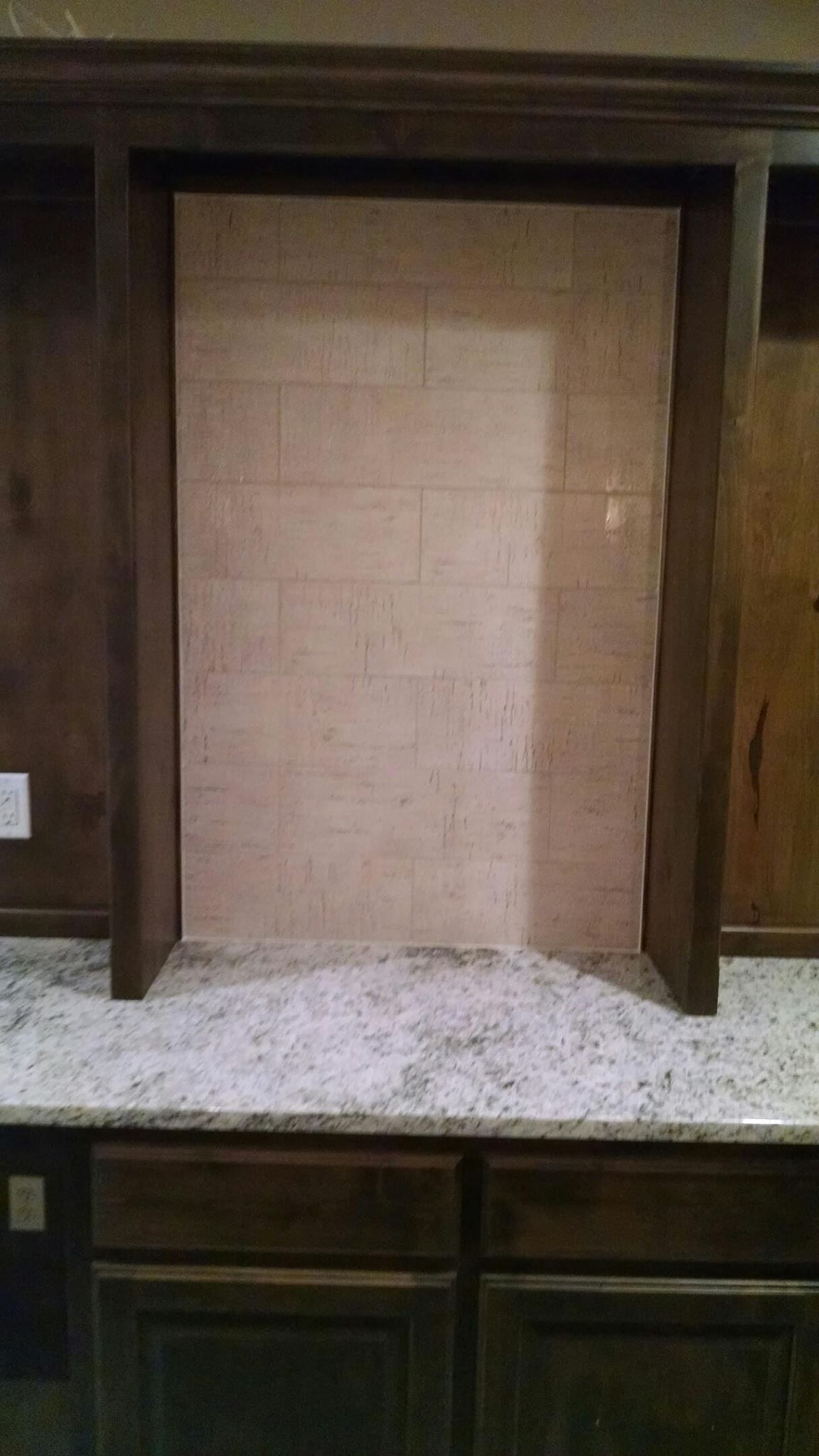 A kitchen with a brick wall and a granite counter top.