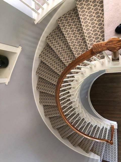 An aerial view of a spiral staircase with a wooden railing