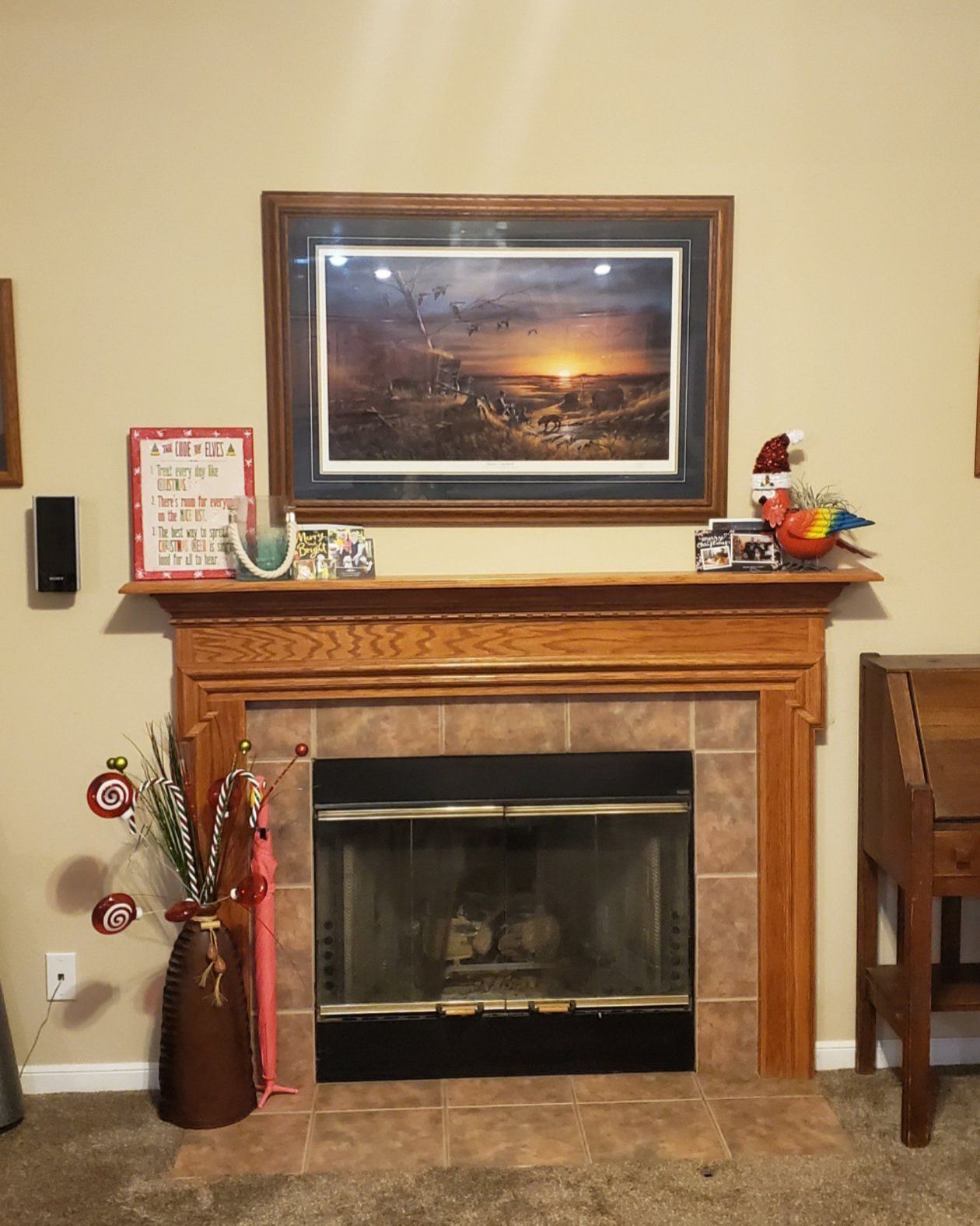 A living room with a fireplace and a picture on the mantle