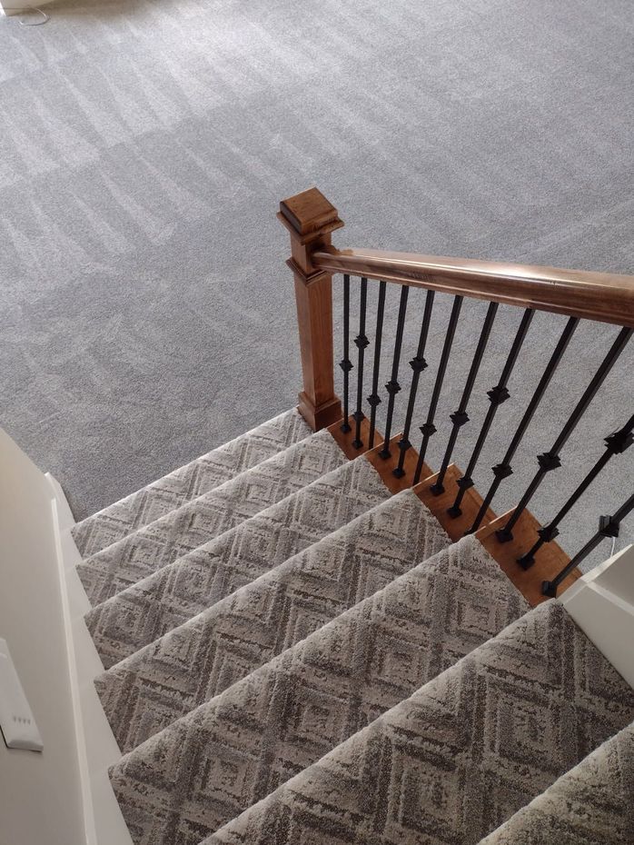 A staircase with a wooden railing and a carpeted staircase.