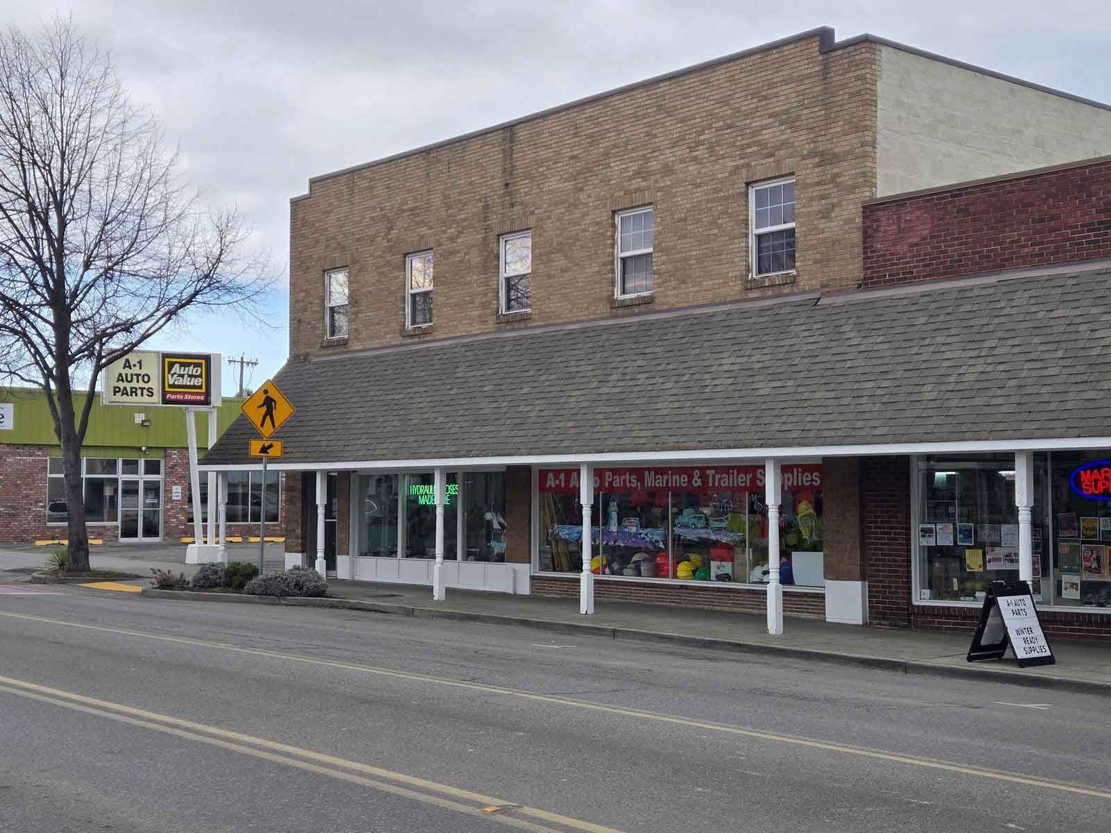 Two-story brick building with storefronts. Sign says 