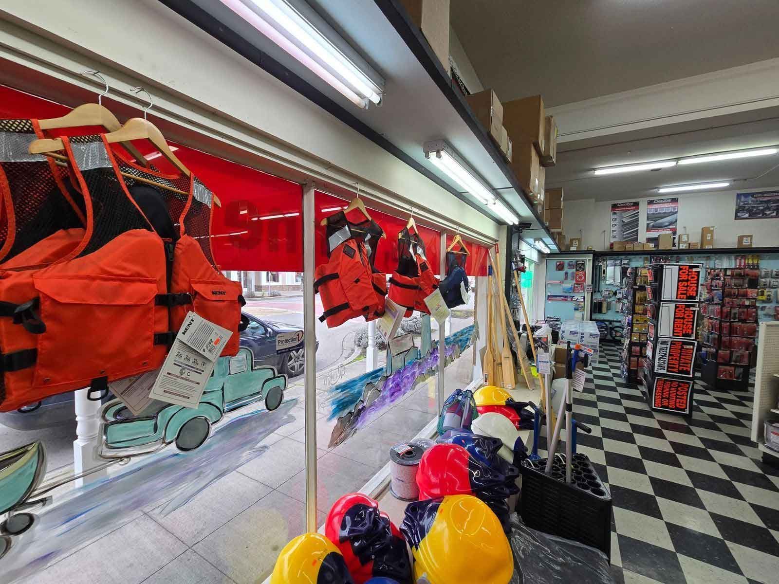 Shop interior with orange life vests, hats, and checkered floor.