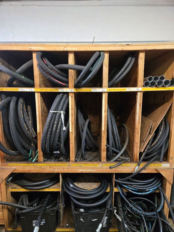 Wooden organizer with hydraulic hoses and pipes.
