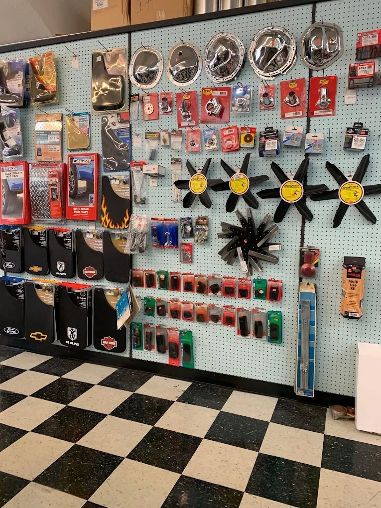 Wall display of auto parts and accessories in an auto parts store with a checkered floor.