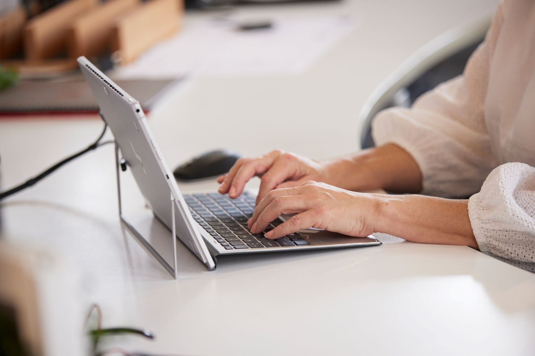 Hands Typing on a Laptop at a White Desk in an Office Setting — Qwerty Plus in Gwandalan, NSW