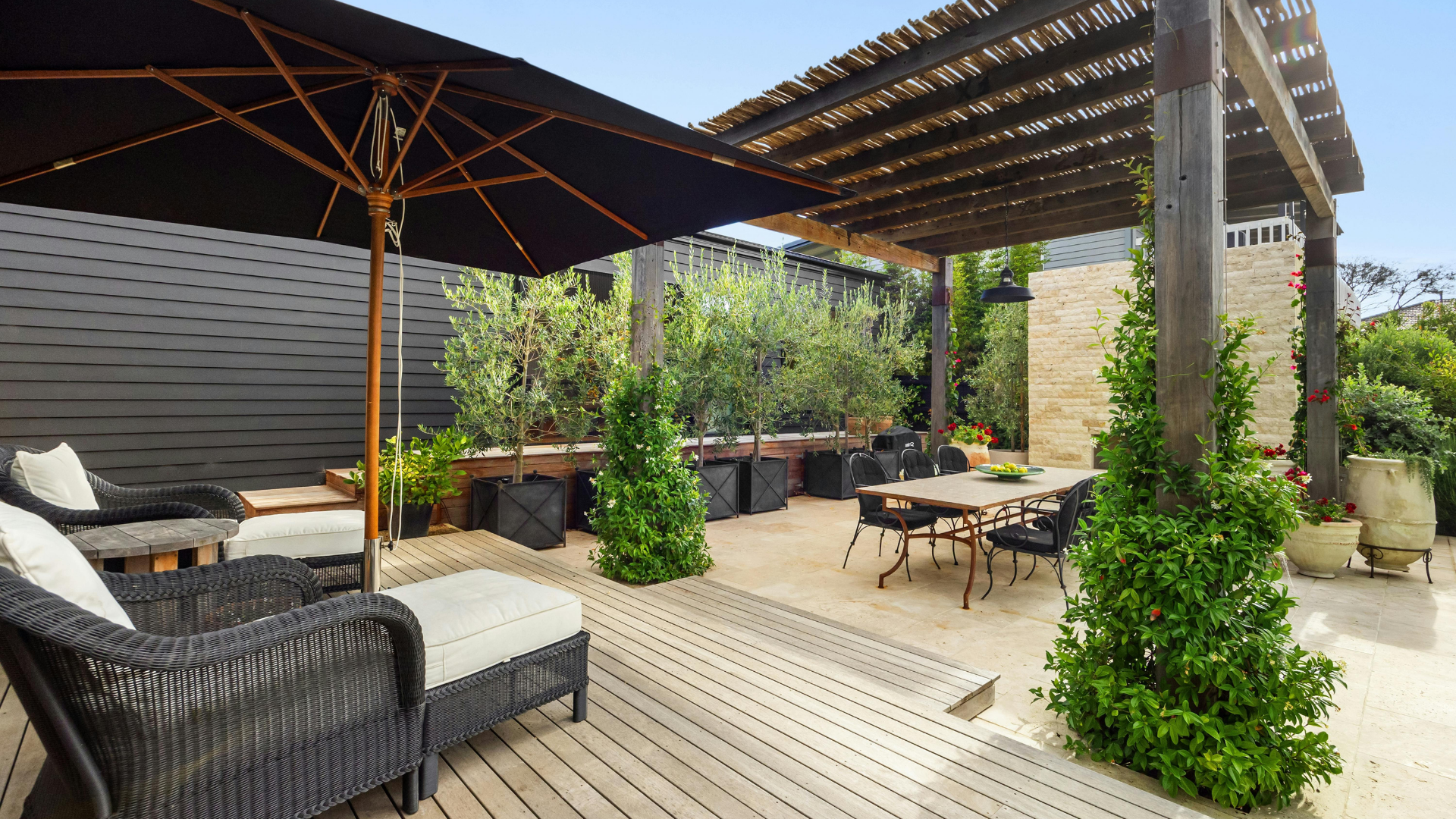 Outdoor patio with a dining area and seating under an umbrella.