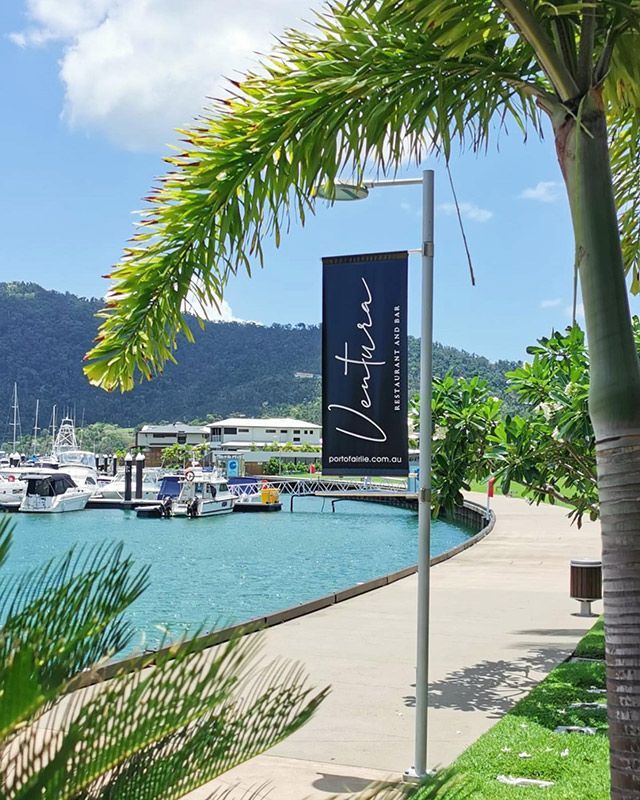 A Distinctive sign for Ventura Restaurant and Bar hangs Gracefully from a pole — Mediterranean Food in Airlie Beach, QLD