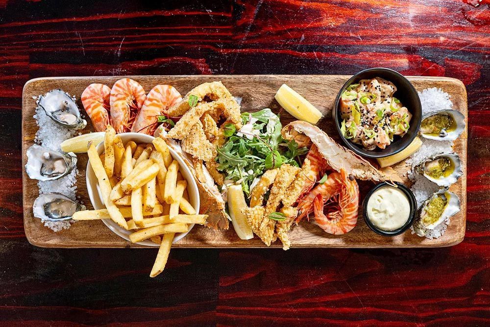 A Tray Of Seafood Including Shrimp Oysters And French Fries — Mediterranean Food in Airlie Beach, QLD