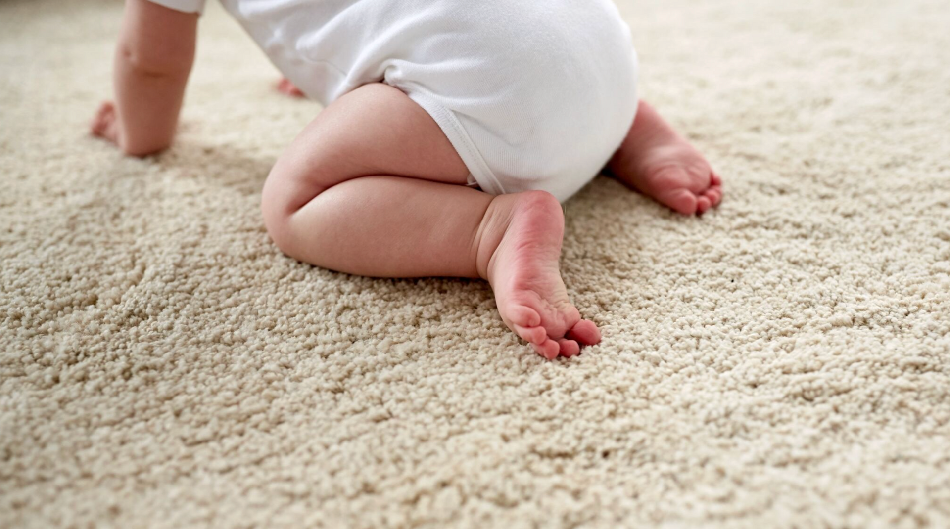A baby crawling on soft carpet
