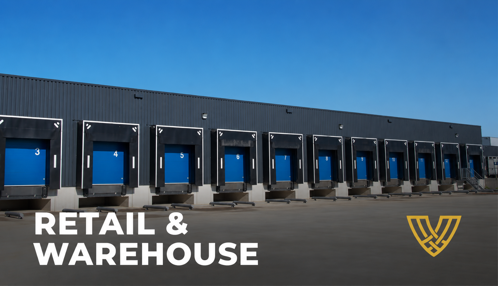 A row of blue loading dock doors on a dark gray warehouse building against a clear sky.