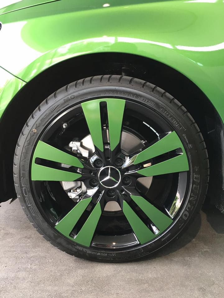 ein grünes mercedes-auto mit schwarzen rädern und einem grünen reifen