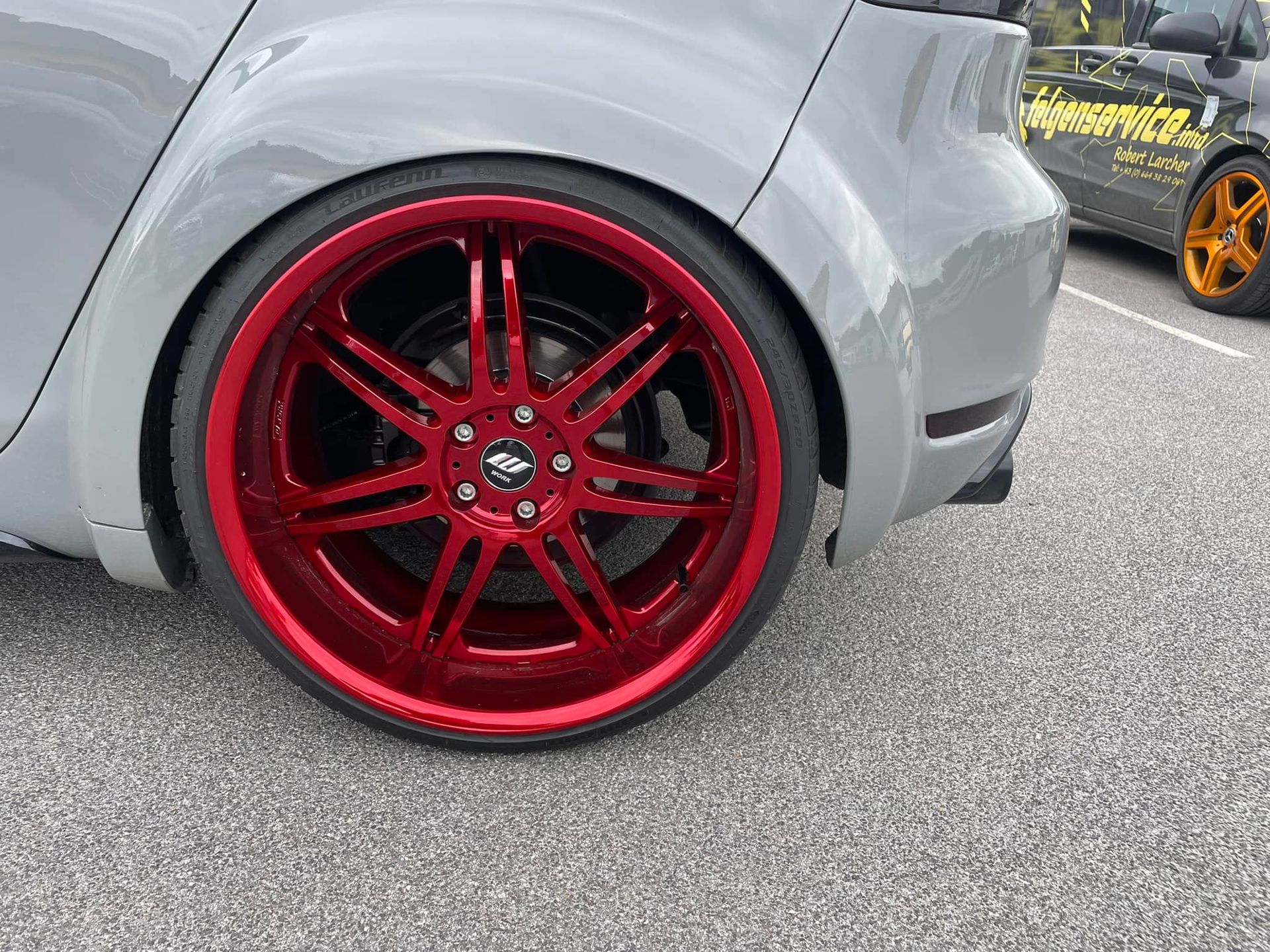 ein graues Auto mit roten Rädern und einem Reifen mit der Aufschrift reifenservice