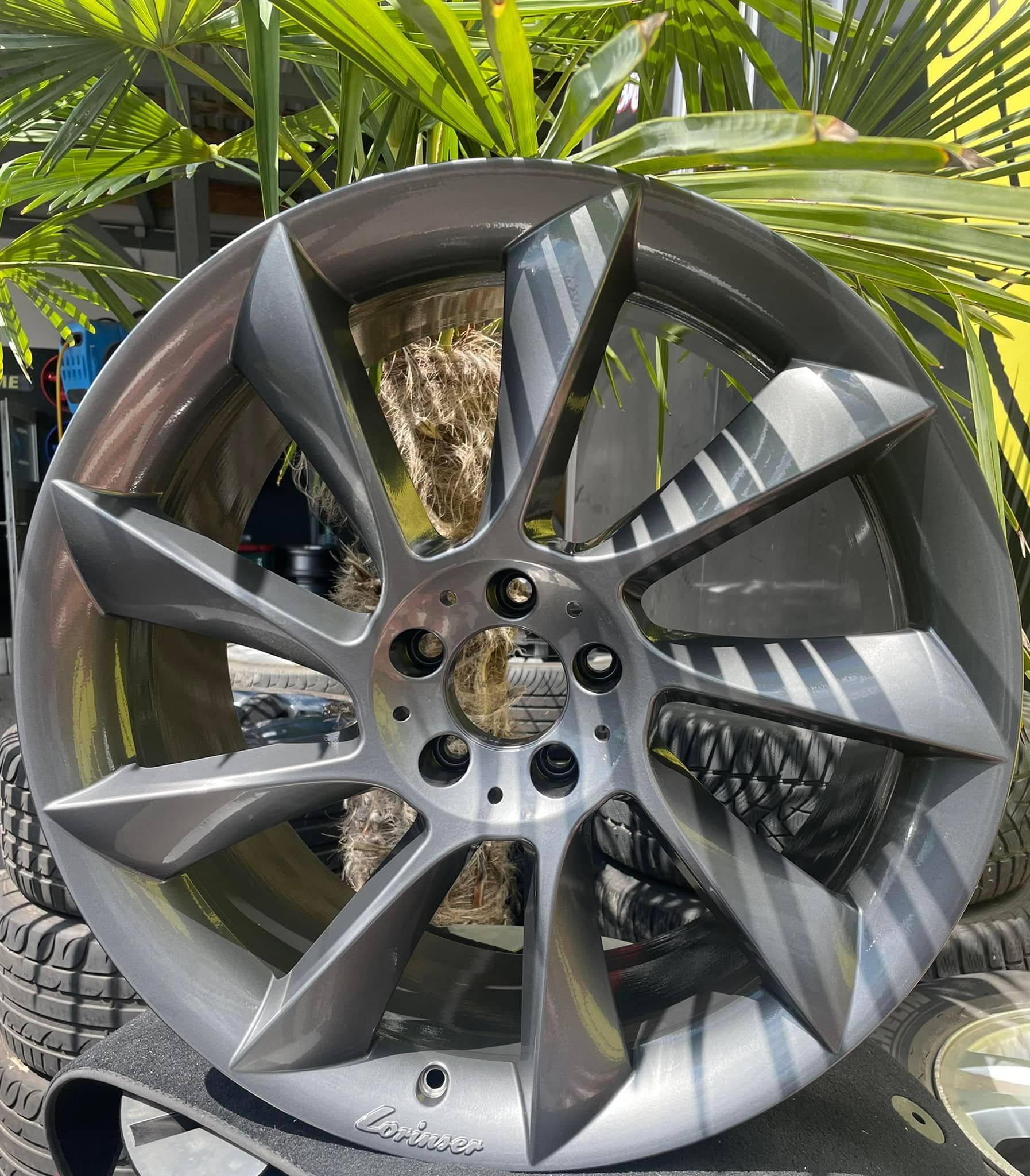 ein graues mercedes-felge steht auf einem stapel reifen