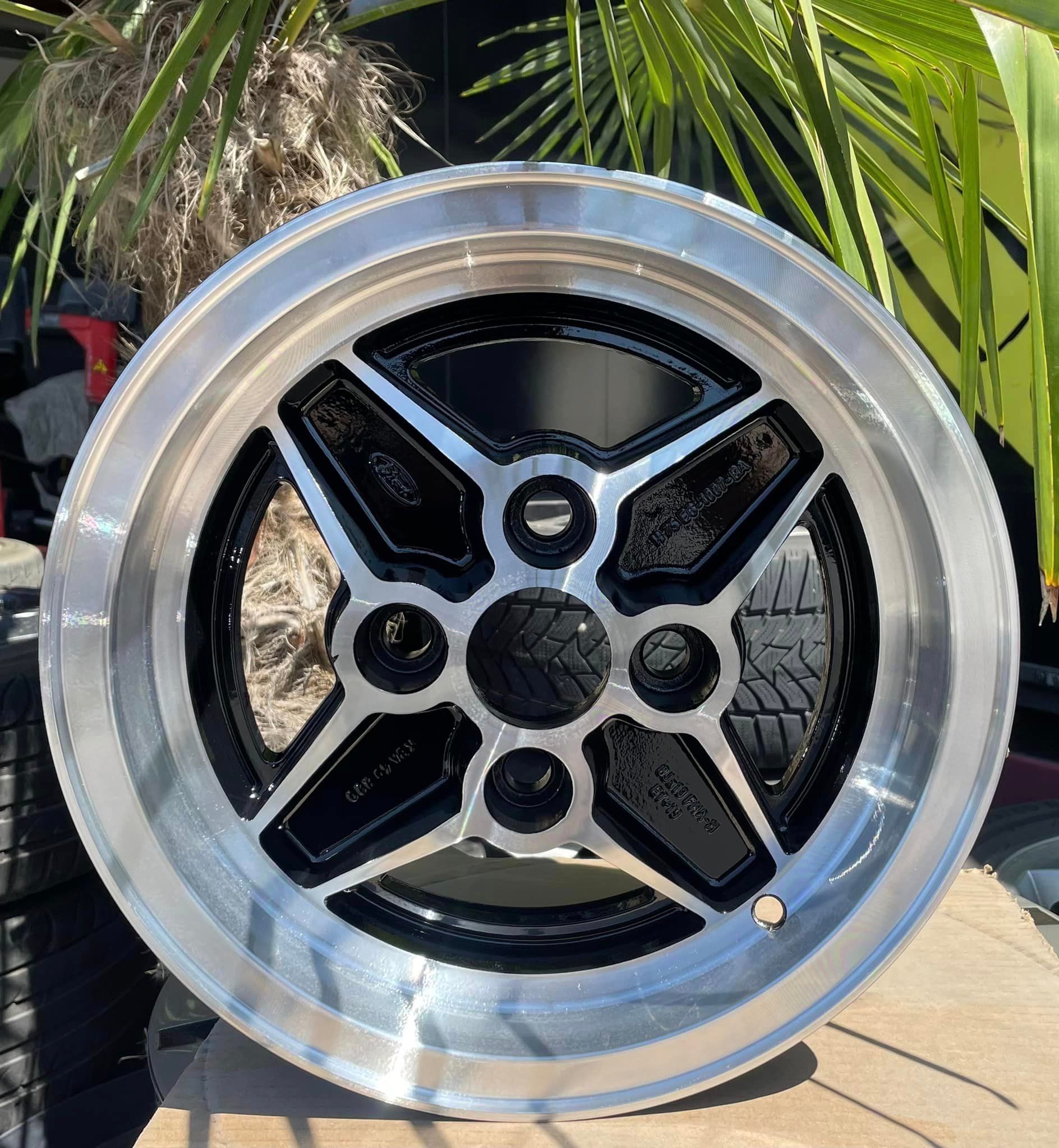 ein schwarz-silbernes ford-Rad sitzt auf einem Tisch neben einer Palme