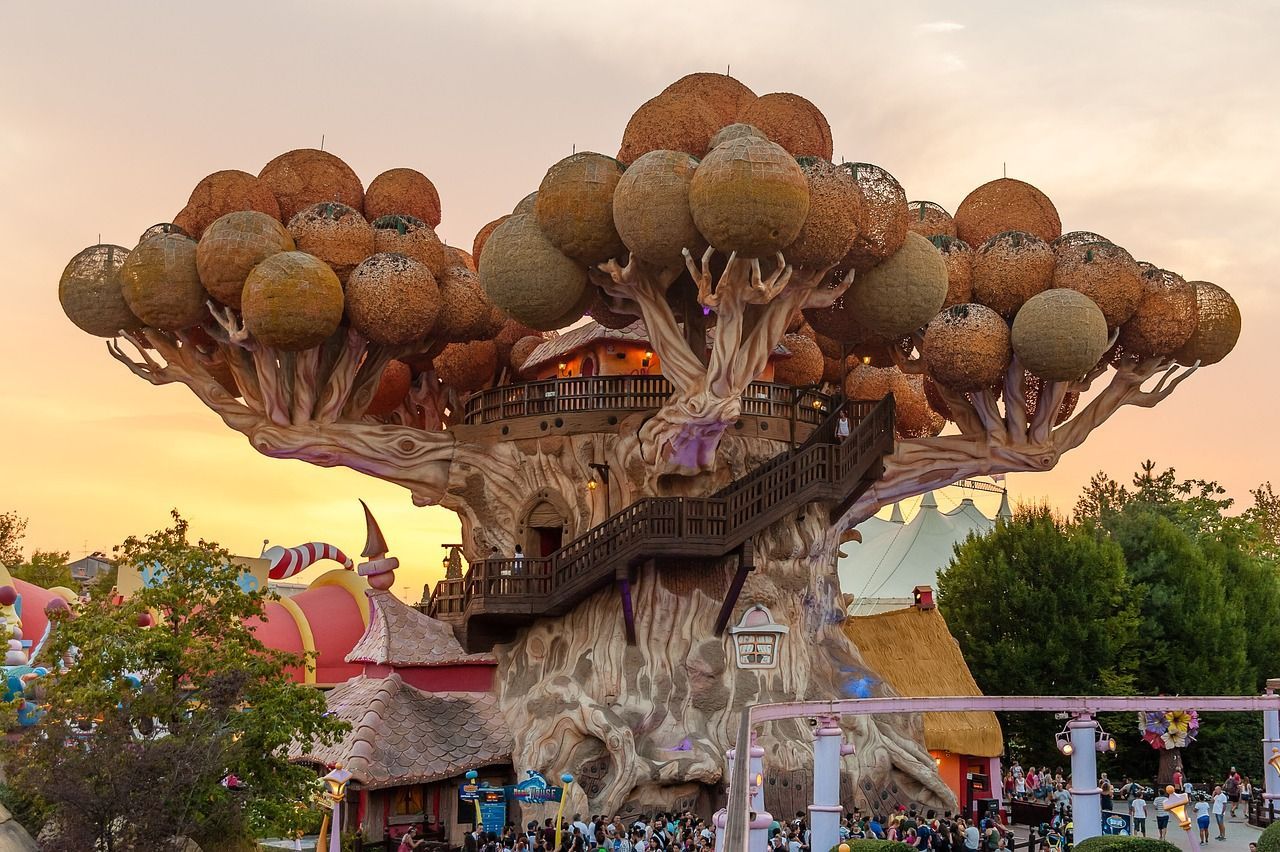 Un grande albero con delle scale che portano verso di esso in un parco divertimenti.