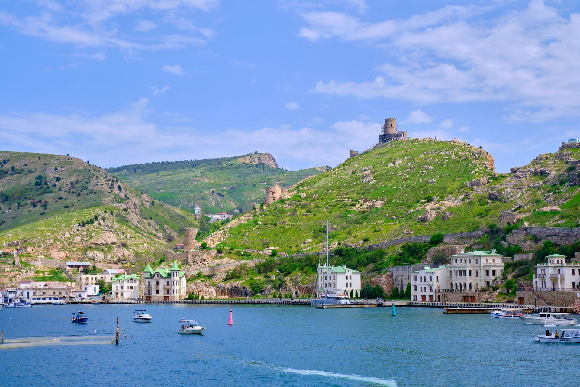 Una grande distesa d'acqua circondata da montagne ed edifici.