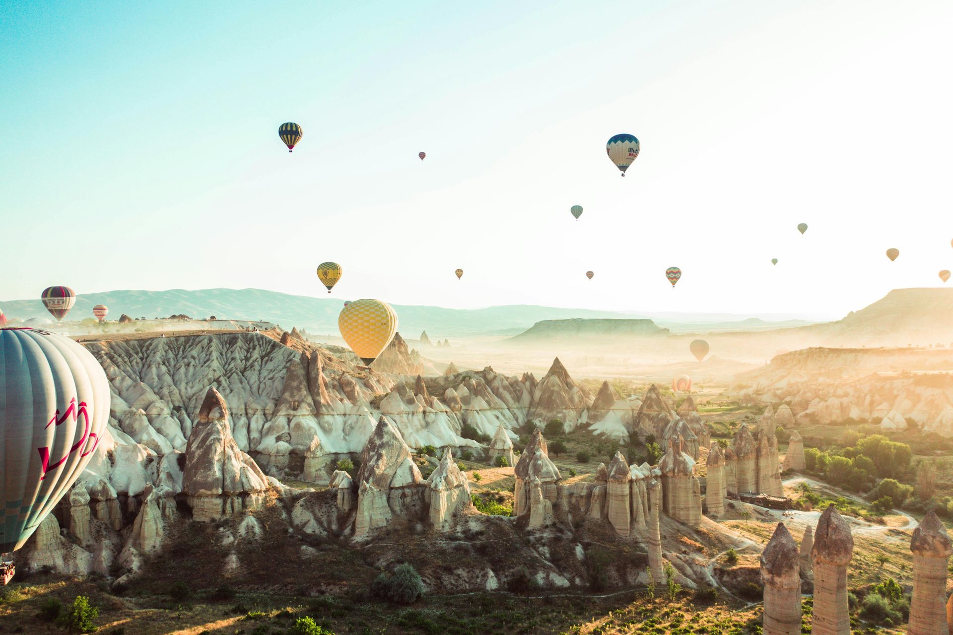 Un gruppo di mongolfiere sta volando sopra una città.