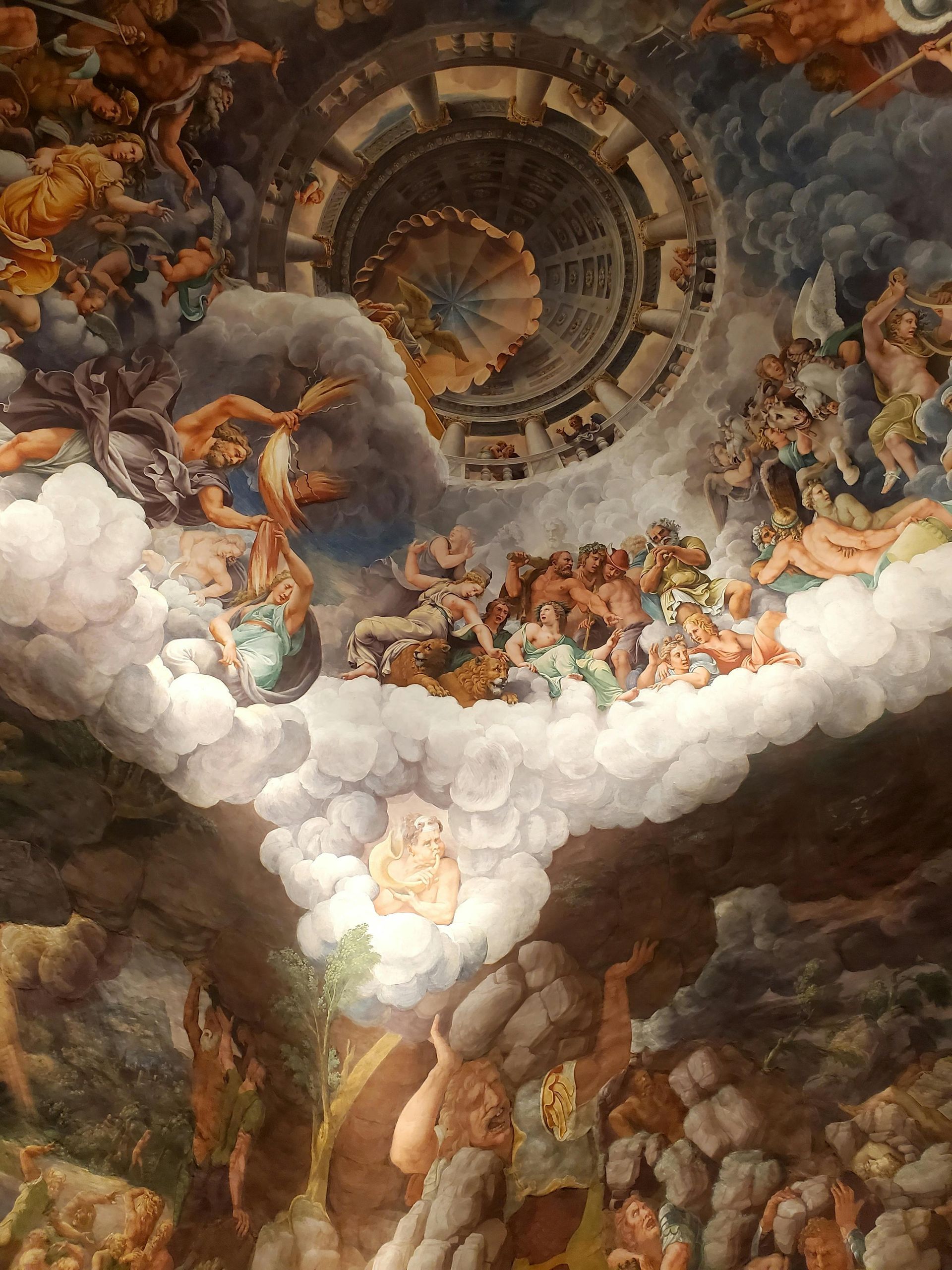 Un dipinto sul soffitto di un edificio con molte nuvole e persone.