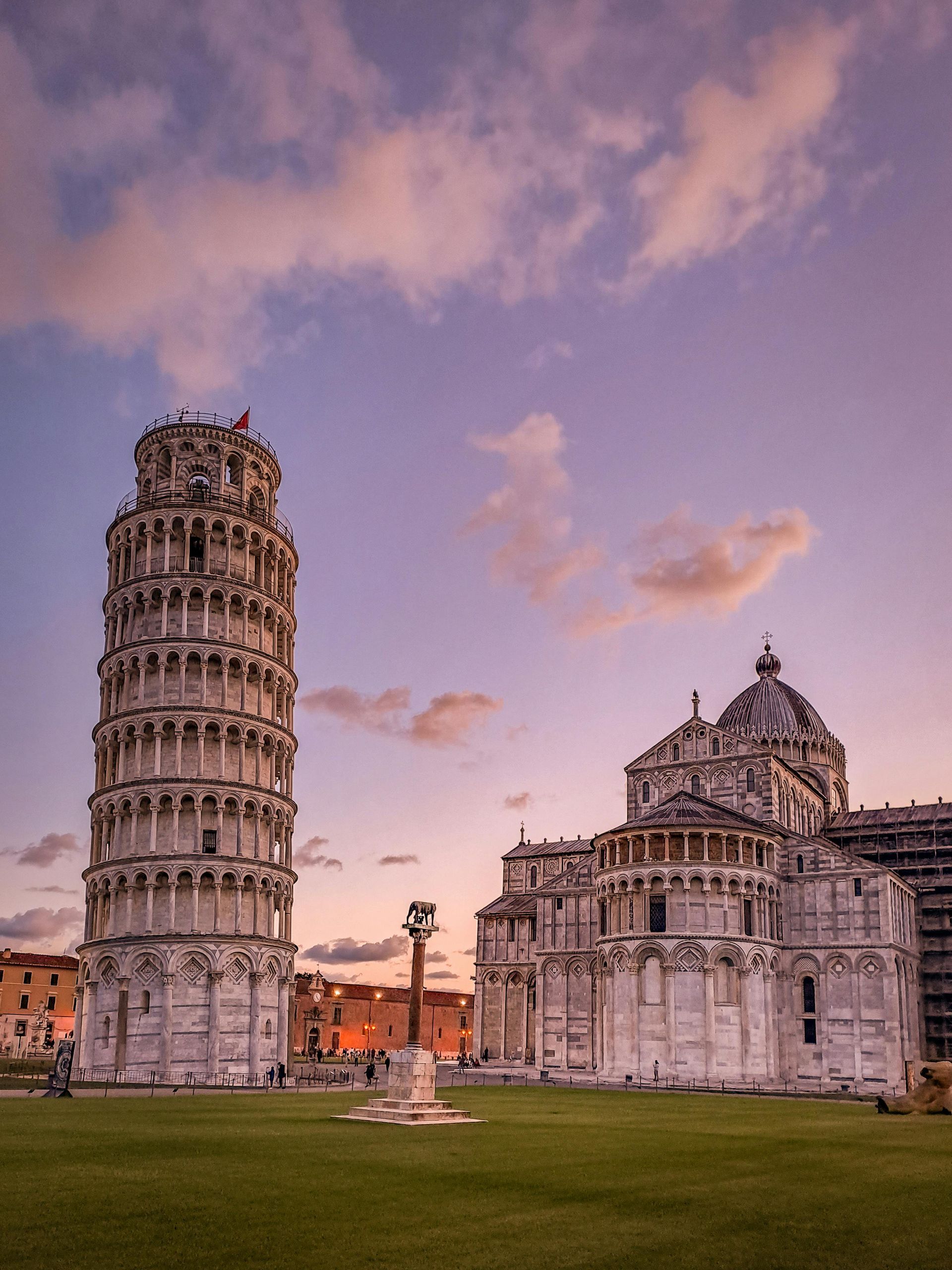 Un edificio molto alto con torre di Pisa molto alta sullo sfondo