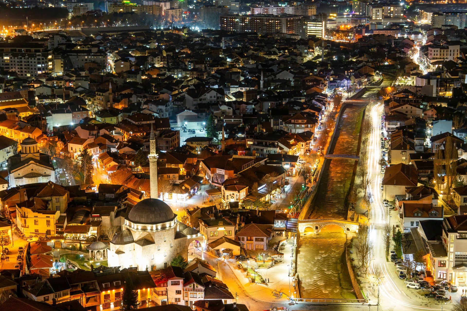 Una vista aerea di una città di notte con una moschea al centro
