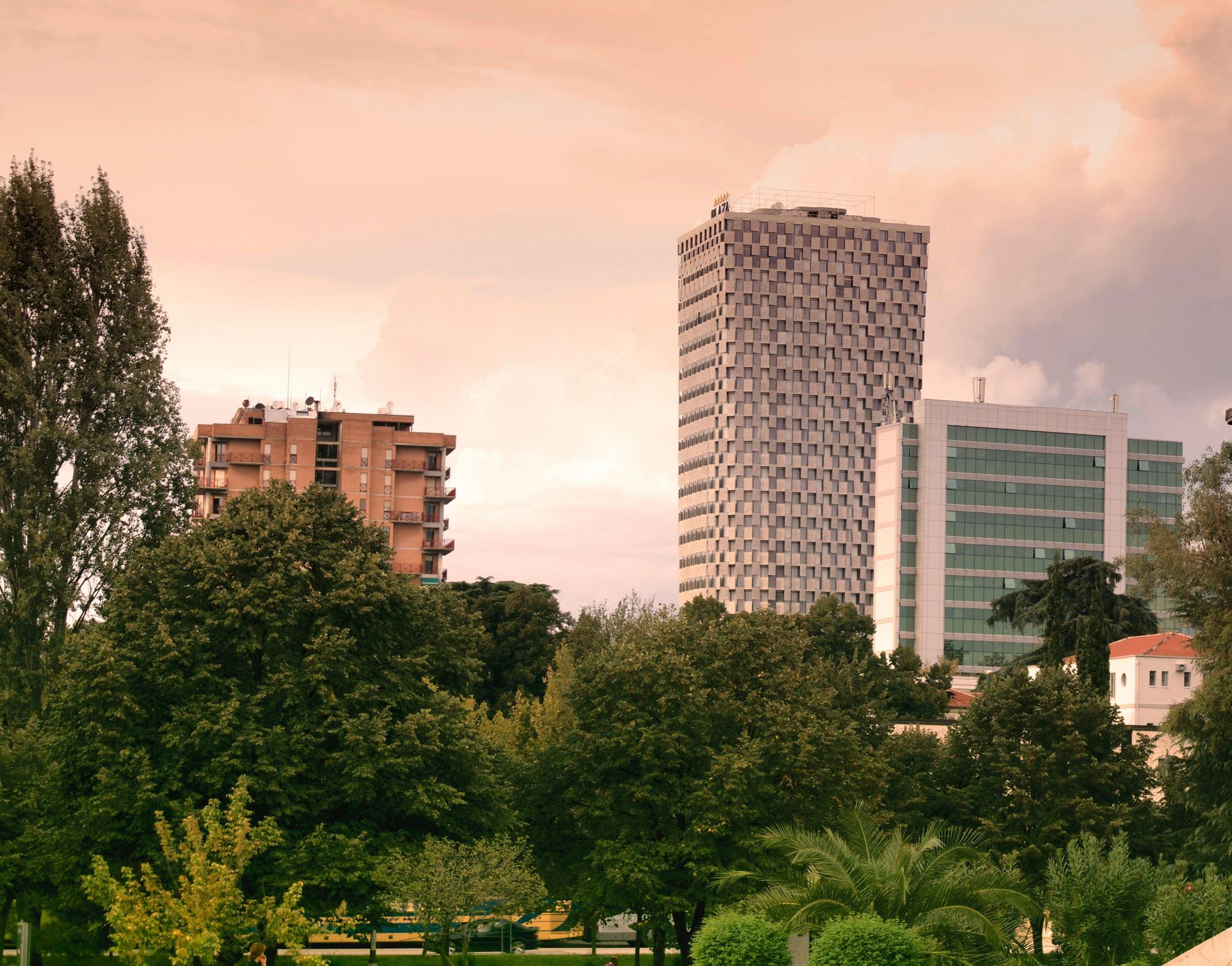 Uno skyline cittadino di Tirana con alberi ed edifici in primo piano