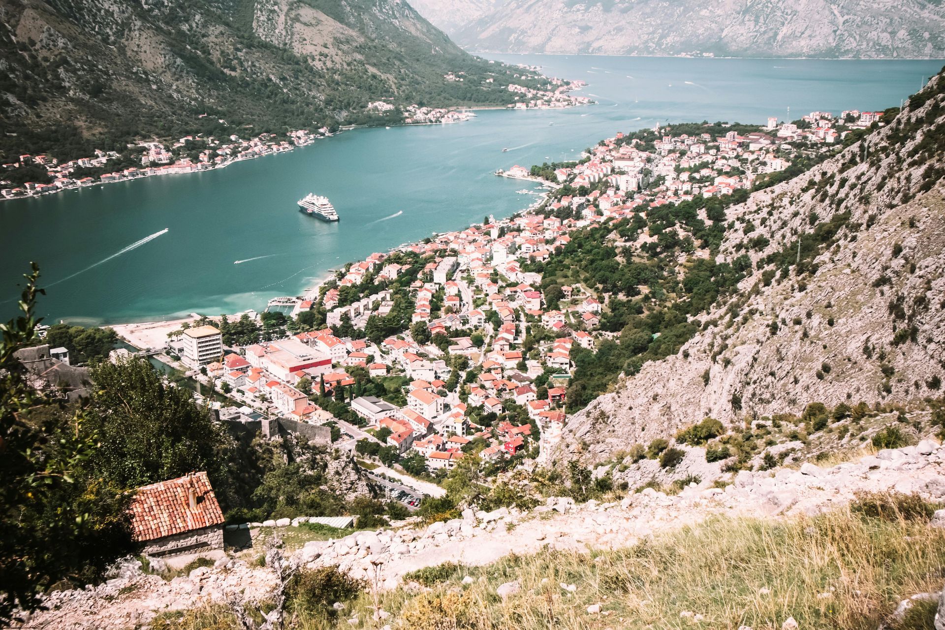 Una grande distesa d'acqua circondata da montagne e da una città.