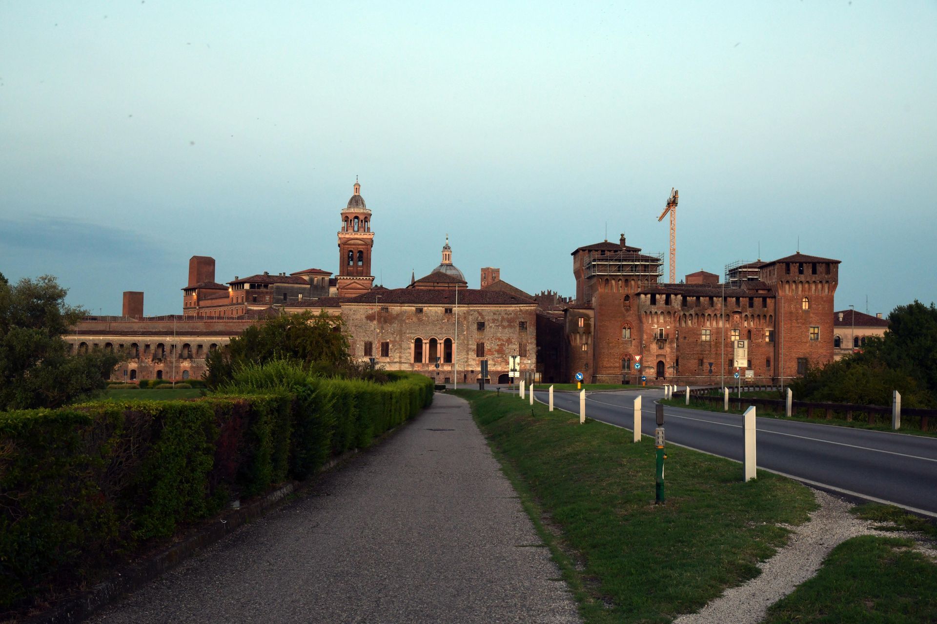 Dietro una strada c'è un grande edificio con una torre dell'orologio.