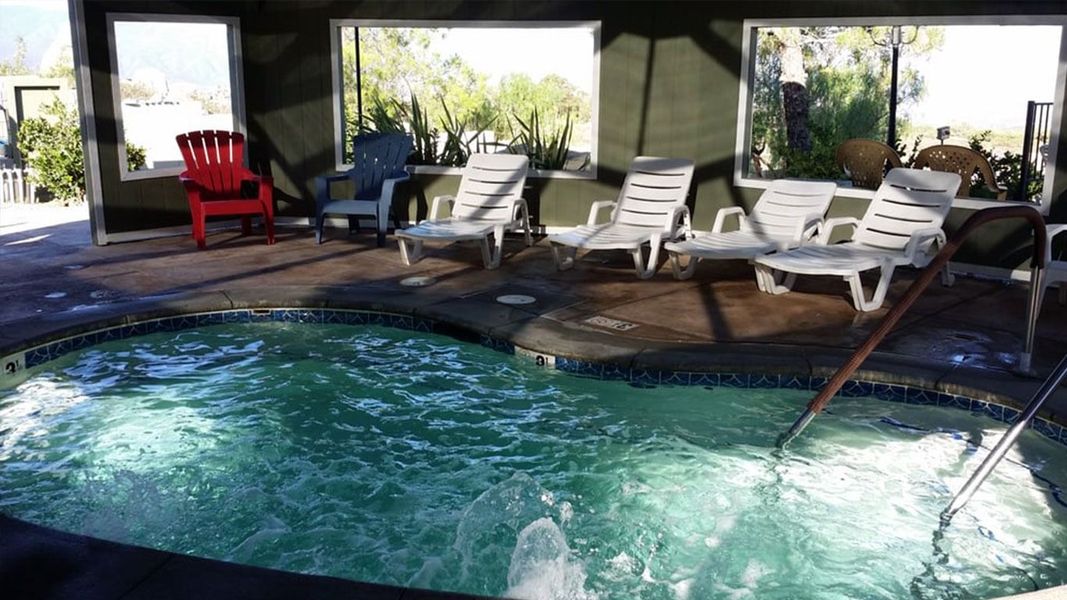 A large indoor swimming pool surrounded by chairs and windows.