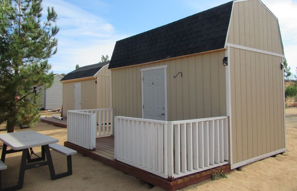A group of small houses are sitting on top of a dirt field.