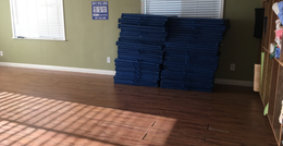 A large empty room with hardwood floors and two windows.