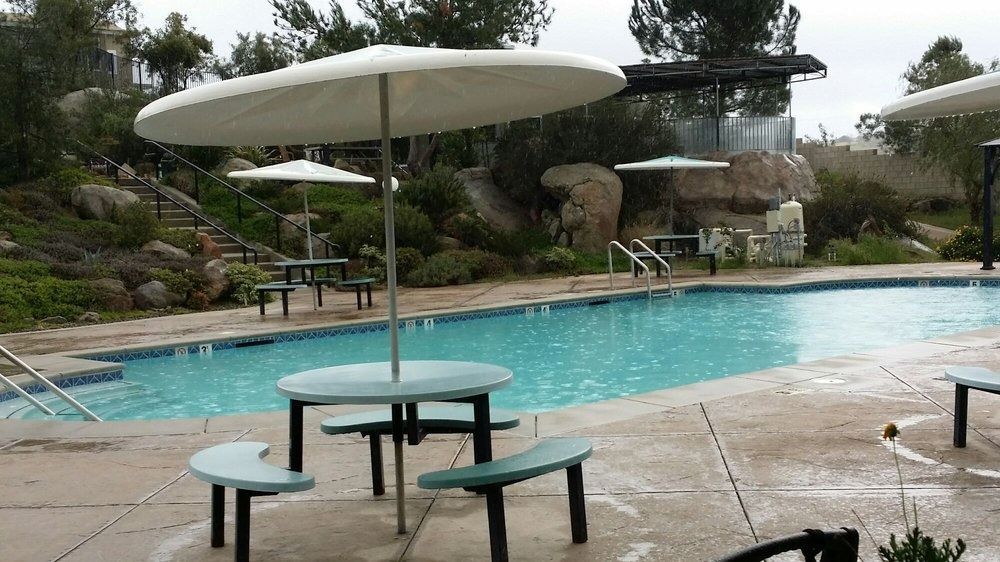 A large swimming pool with umbrellas and chairs around it