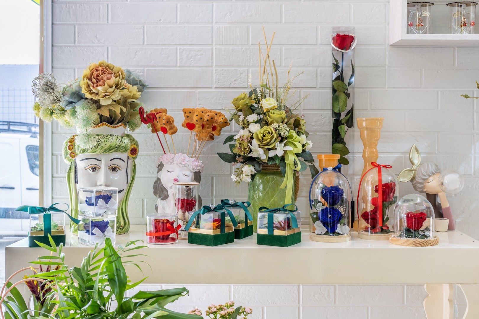 Uno scaffale pieno di vasi pieni di fiori e candele.