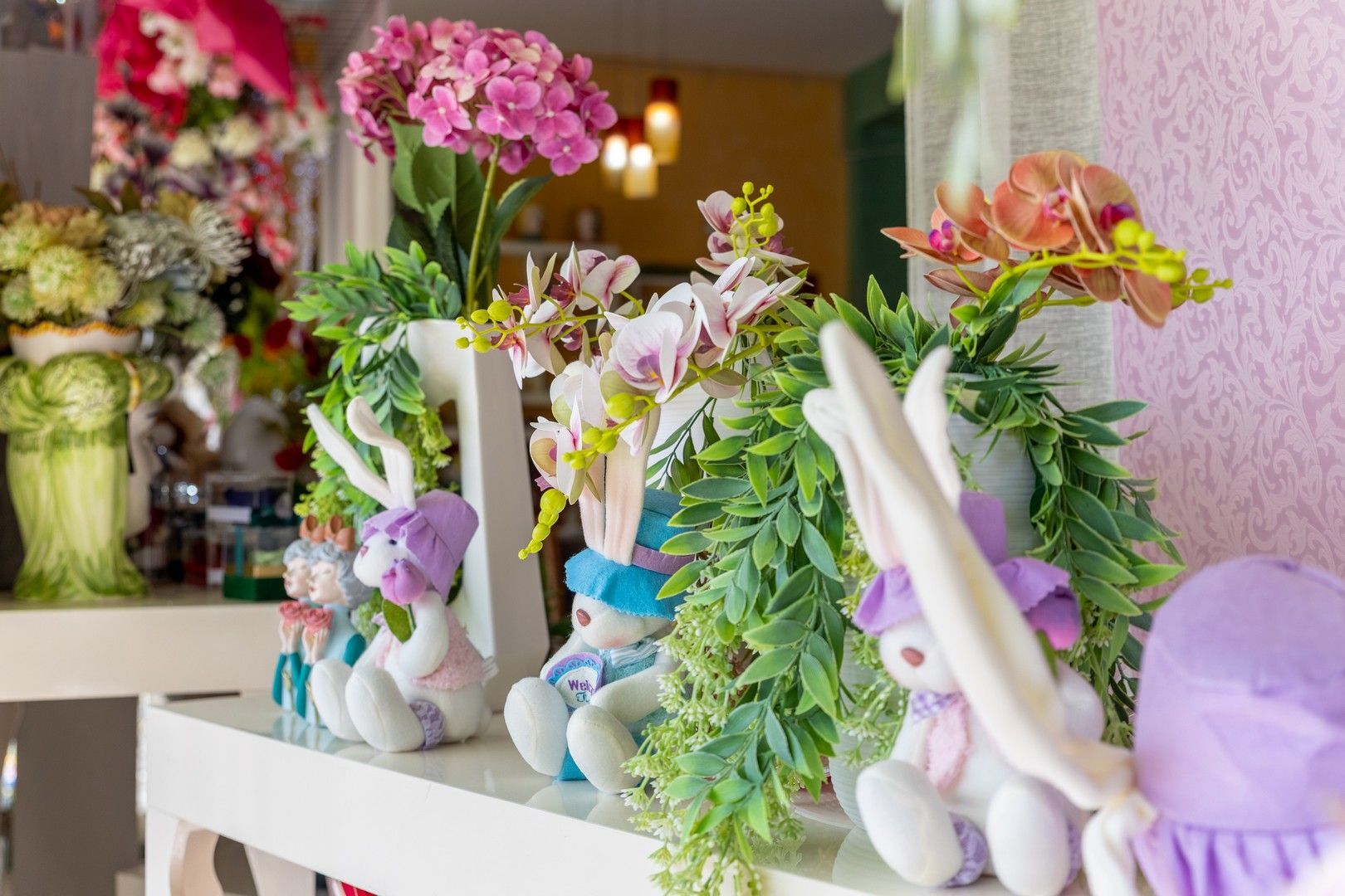 Un tavolo con sopra un mucchio di animali di peluche e fiori.