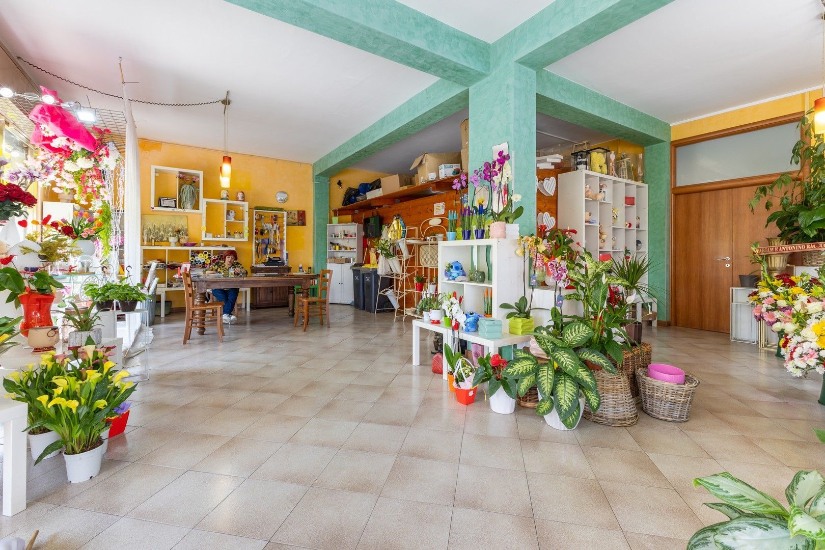 Una grande stanza piena di piante in vaso e fiori.